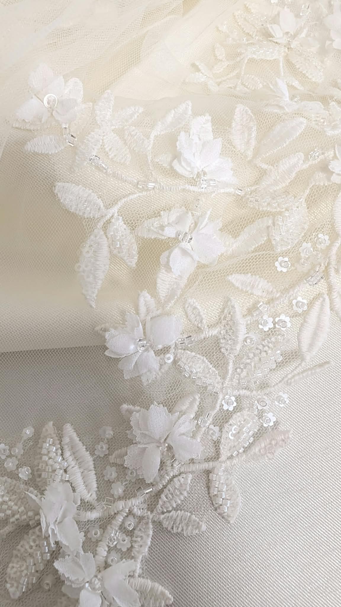 rimer plano de un velo de novia de tul soft con intrincados apliques de encaje con flores en 3D, bordados de hojas y detalles de pedrería y lentejuelas de Zulema Torres