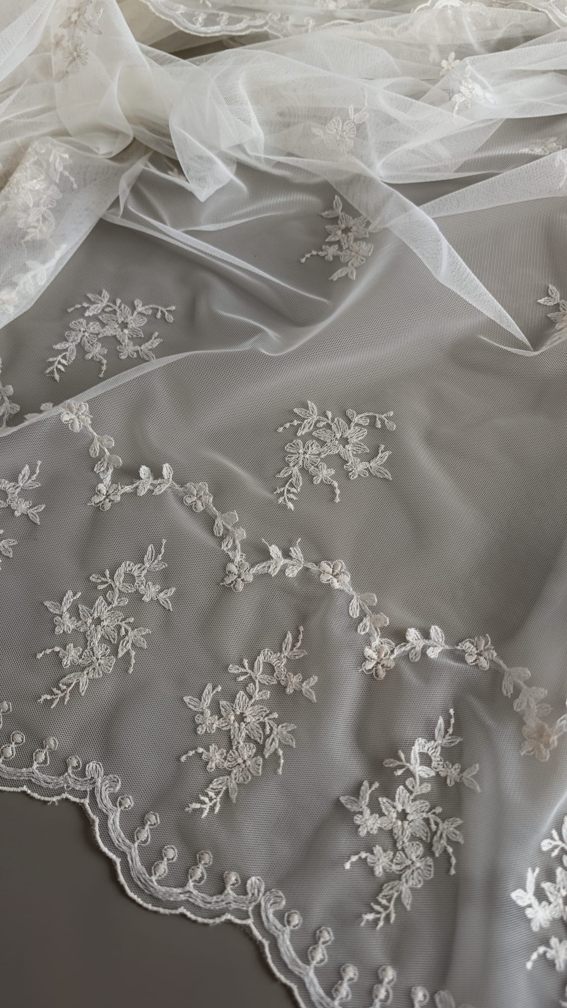 Primer plano de la blonda perimetral de encaje floral bordado con ondas caladas de la mantilla 758 de Zulema Torres.