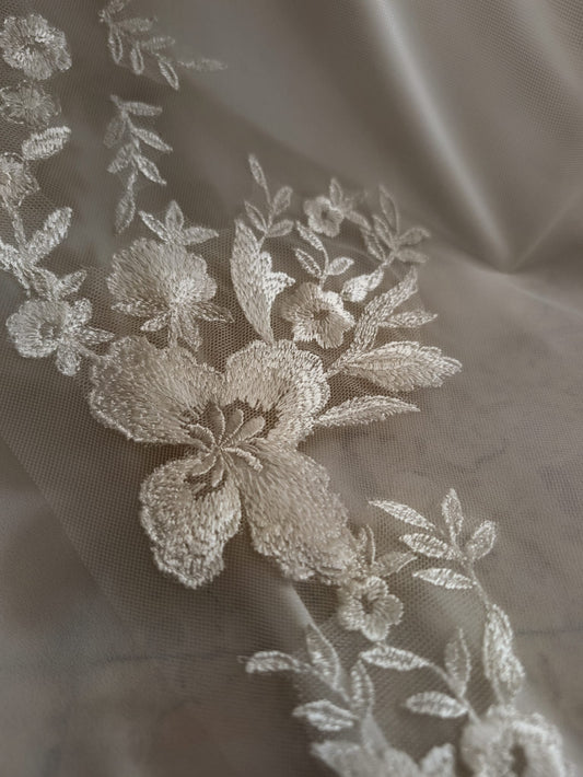 Detalle de los apliques de encaje floral y pedrería en un velo de novia de tul de Zulema Torres.