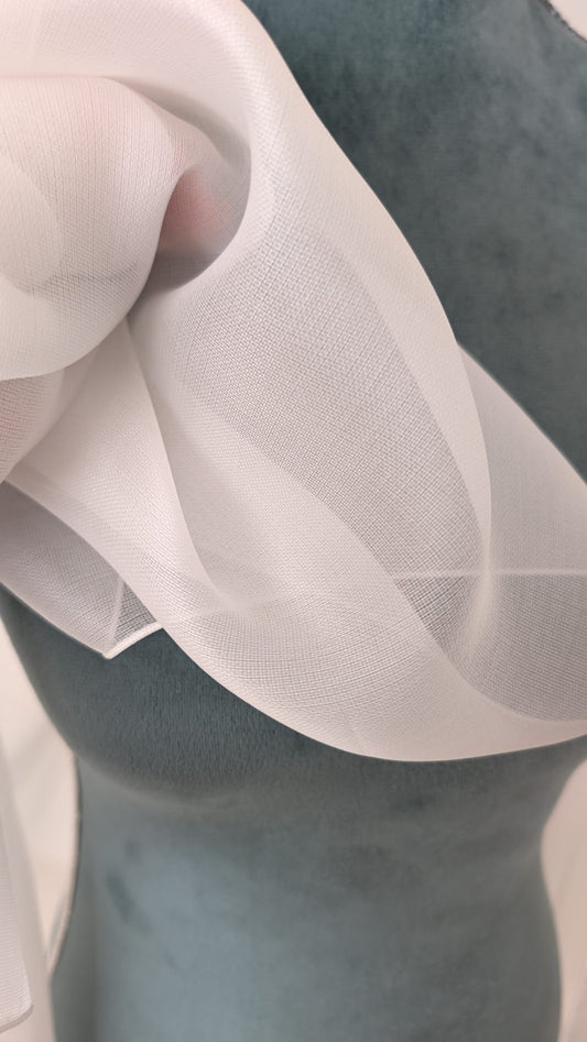 Primer plano técnico que muestra el grano fino y la transparencia de la organza de seda natural blanco natural para novias.