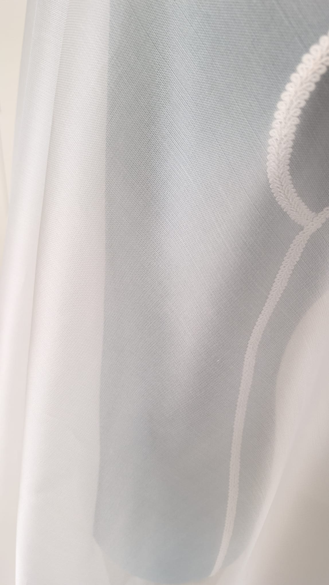 Detalle del drapeado y la textura sedosa de un velo de novia de organza de alta costura de Zulema Torres.