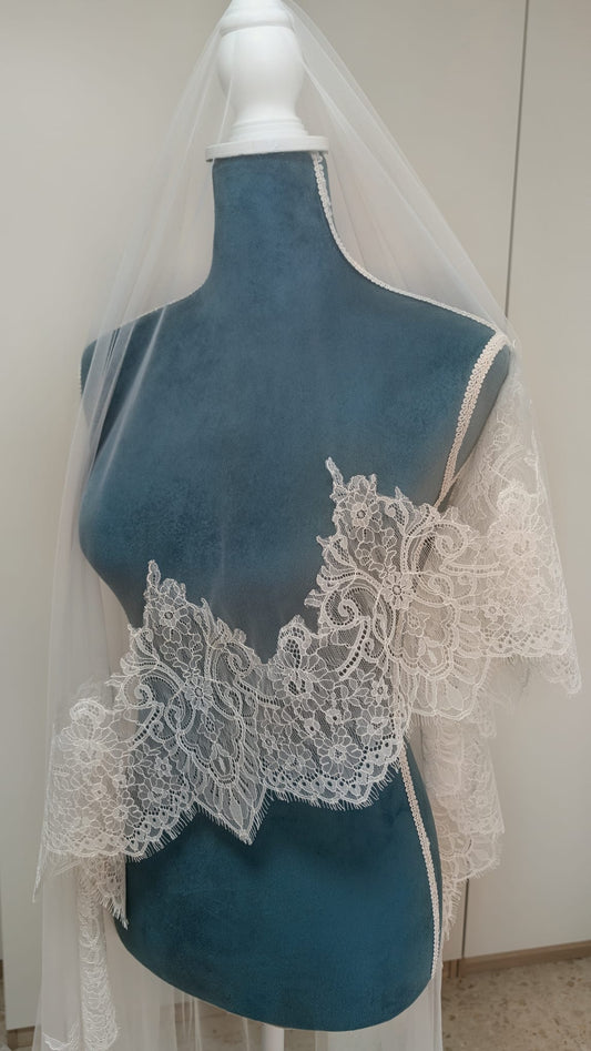 Primer plano del encaje Chantillí fino con ondas y detalles de pestañas caladas en un velo de novia de Zulema Torres.