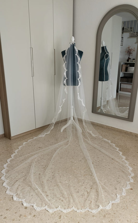 Vista completa de un velo de novia de 2x3 metros con encaje perimetral de guipur sobre maniquí y cola extendida.